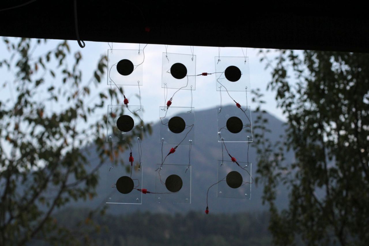 small glasses hanging from the ceiling of a terrace, mountain background